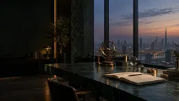 A dark green marble desk with an open notebook, brass instruments and a glass globe, before a window onto a city skyline at dusk