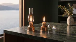 Two identical brass oil lanterns burning with the same flame on a green marble desk, the right one with its glass chimney lifted off and lying beside it